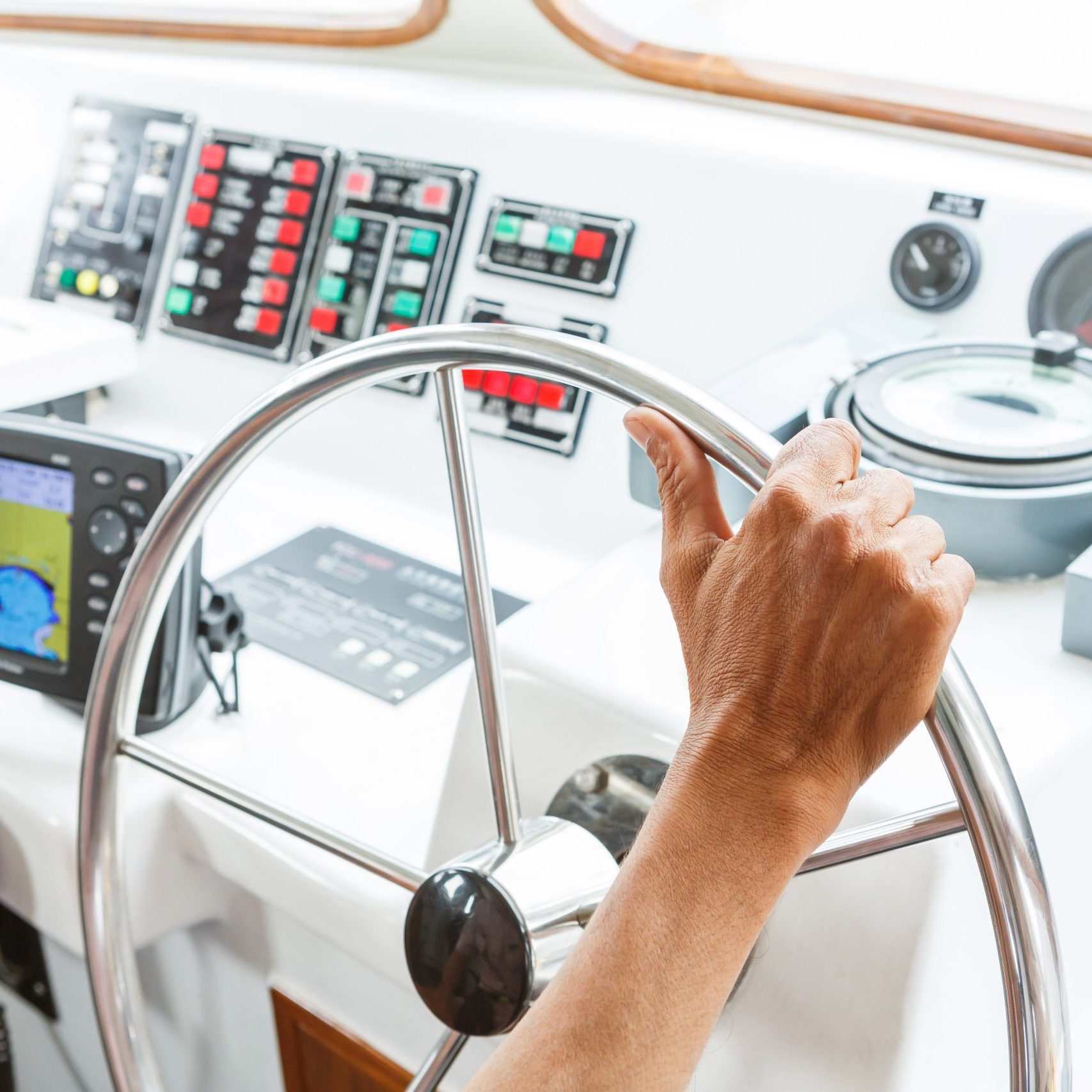 Close up captain hand on boat steering wheel